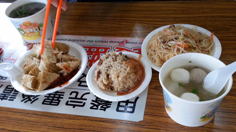 A photo of a table with a variety of food and a cup of soup.